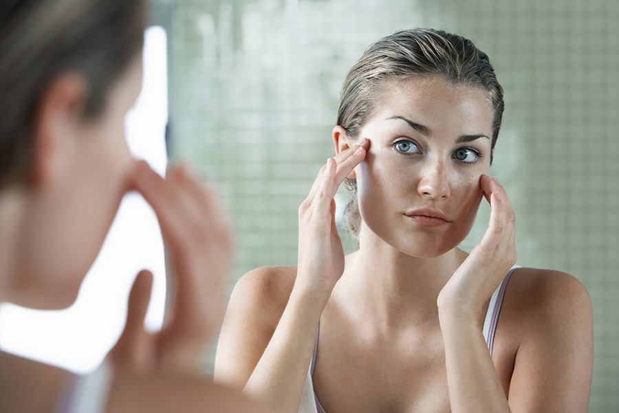 Woman looking at herself in the mirror